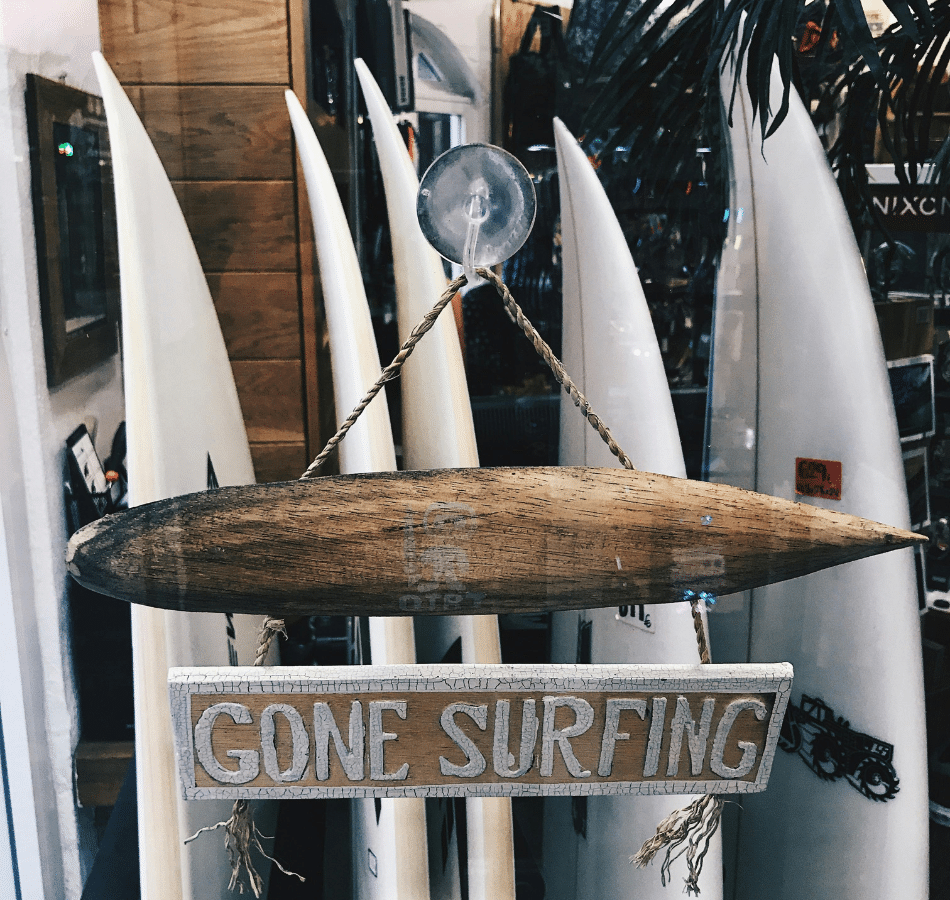 Surf shop closed sign reading 'Gone Surfing', illustrating work-life balance